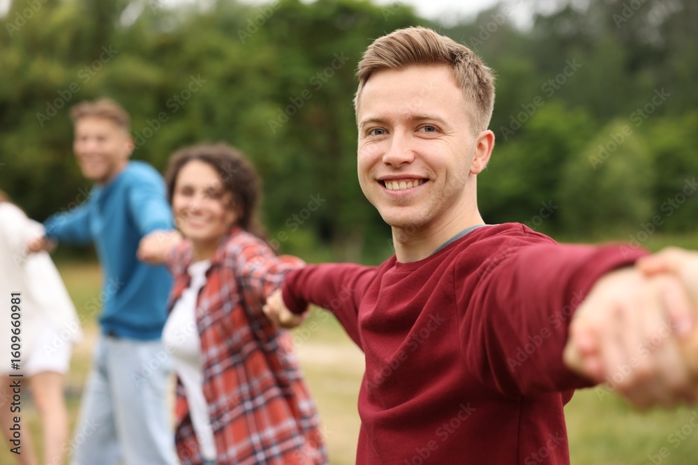 Fototapeta premium Team building. Group of happy people holding hands outdoors, selective focus