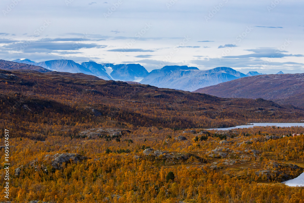 Obraz premium Autumn landscape of Kilpisjarvi, Finland, showcasing colorful foliage, serene lakes, and majestic mountains in the background.