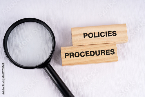 Magnifying glass and text policies and procedures on white background