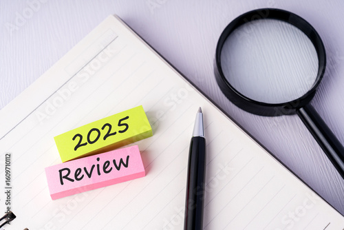 Magnifying glass and sticky paper notes with text 2025 review