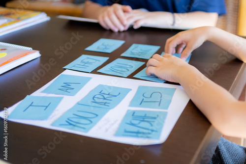 Child learning english grammar with flash cards at home