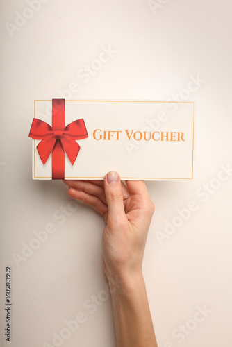 Top view of woman holding gift voucher with 500 value lettering on white background