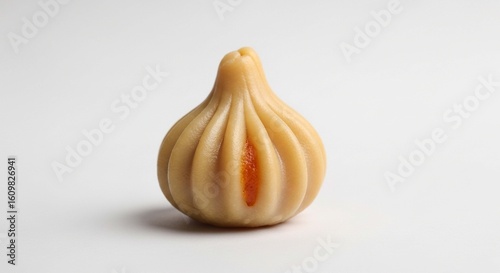 A single, beautifully crafted modak, a traditional Indian sweet, isolated on white.
