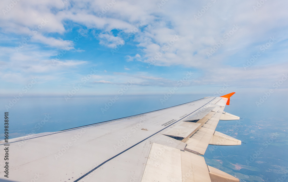 Obraz premium View from the airplane window at a beautiful cloudy sky and the airplane wing