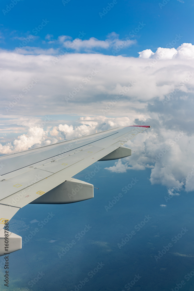 Obraz premium View from the airplane window at a beautiful cloudy sky and the airplane wing
