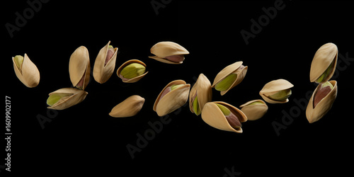 Flying falling pistachio nuts isolated on black background
