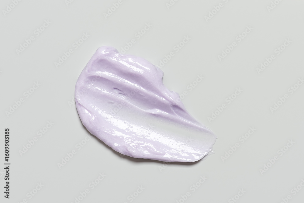 Fototapeta premium Smear of cosmetic purple cream on gray background, top view, texture moisturizer