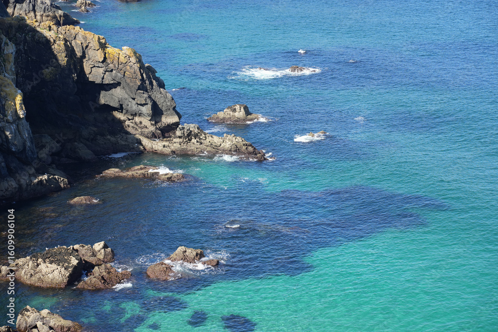 Obraz premium A stunning high-angle view of a cove in Brittany, showing incredibly clear turquoise water over submerged rocks.