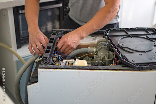 The master repairs the dishwasher at home