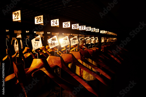 Photos Wooden hangers with numbers in dark cloakroom
