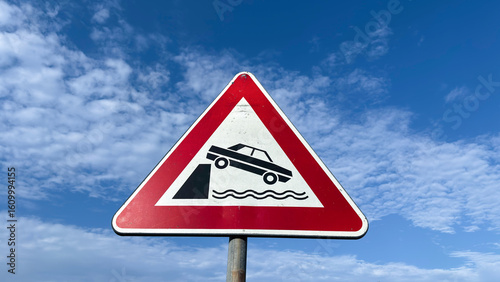 Road sign warning of the danger of falling into the water on an unprotected dock.