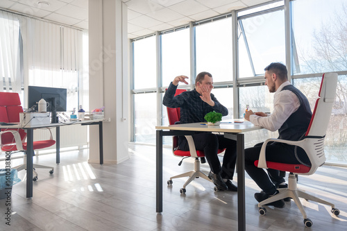 Two Caucasian men communicating at a business meeting. 