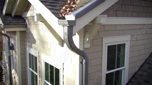 Exterior view of a house with gray gutters and a light beige siding