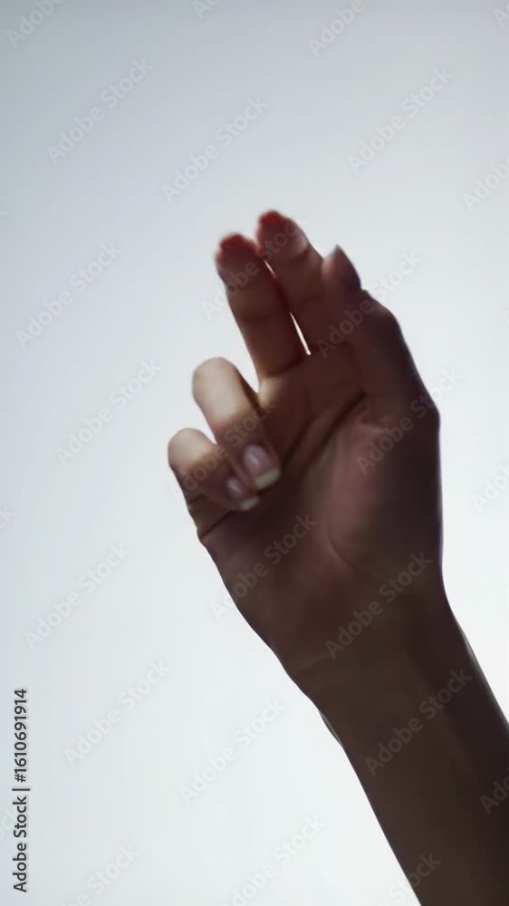 A well-groomed human hand extends into frame, performing a gentle pinch gesture to interact with an invisible digital interface against an immaculate, transparent, sterile backdrop with soft high-key A well-groomed human hand extends into frame, performing a gentle pinch gesture to interact with an invisible digital interface against an immaculate, transparent, sterile backdrop with soft high-key