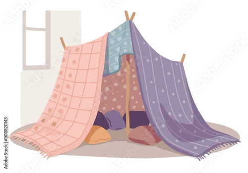 Colorful blanket fort made with cloths and cushions on floor  