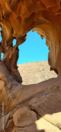  Natural Rock Arch on Fuerteventura Framing the Desert Landscape under Blue Sky