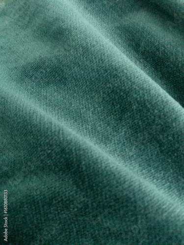 Close-up of deep green velvet fabric texture. Ideal for backgrounds and designs needing a touch of luxury and elegance. Perfect for fashion, textiles, and creative projects.