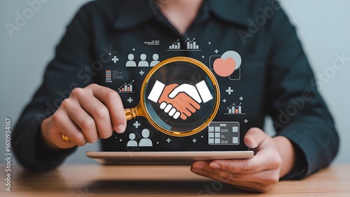 Seeking strategic partnerships and business growth with magnifying glass on handshake deal icon