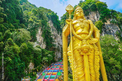 View of Batu Caves with the colorful steps and the Hindu statue located in the north of Kuala Lumpur, Malaysia.
