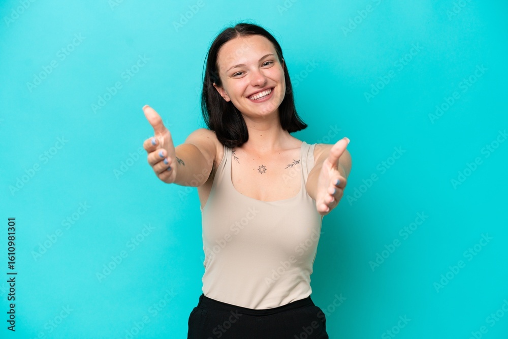 Fototapeta premium Young caucasian woman isolated on blue background presenting and inviting to come with hand