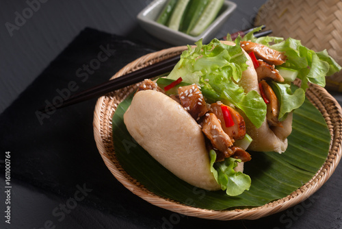 Food concept Homemade organic chicken Bao Buns or Gua Bao in bamboo stream tray on black background with copy space