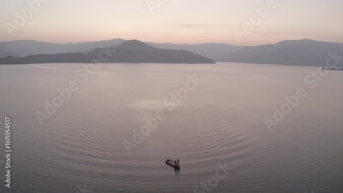 boat sailing in river hills in background sunset