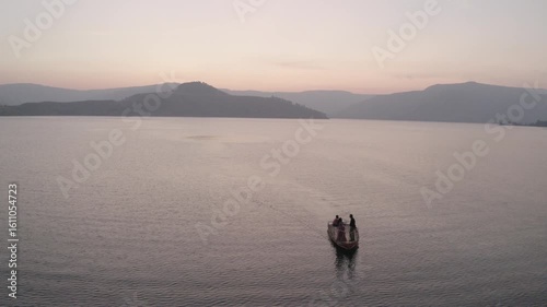 boat sailing in river hills in background sunset