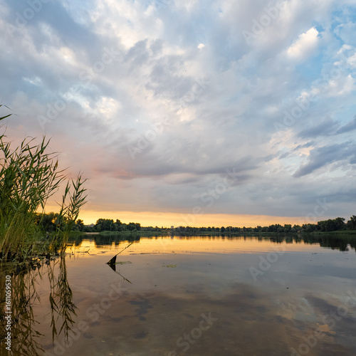 very beautiful sunset with water. summer evening landscape with reflection of clouds in water. setting sun on horizon. summer landscape with lake. reflection of trees in water. sunrise on river