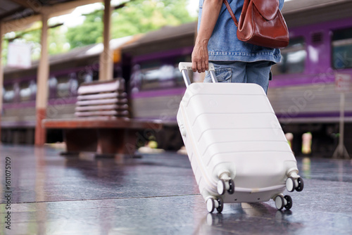 Older Asian hand pulling white suitcase luggage travel journey train station platform transport trip vacation holiday