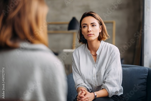 A compassionate therapist fostering trusting, attentive conversation in a sleek, serene studio.