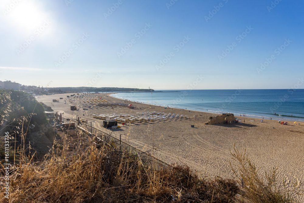 View of Praia da Rocha beach in Portimão, Algarve, Portugal. Golden sand, dramatic cliffs and blue Atlantic ocean under a clear summer sky. View of Praia da Rocha beach in Portimão, Algarve, Portugal. Golden sand, dramatic cliffs and blue Atlantic ocean under a clear summer sky.