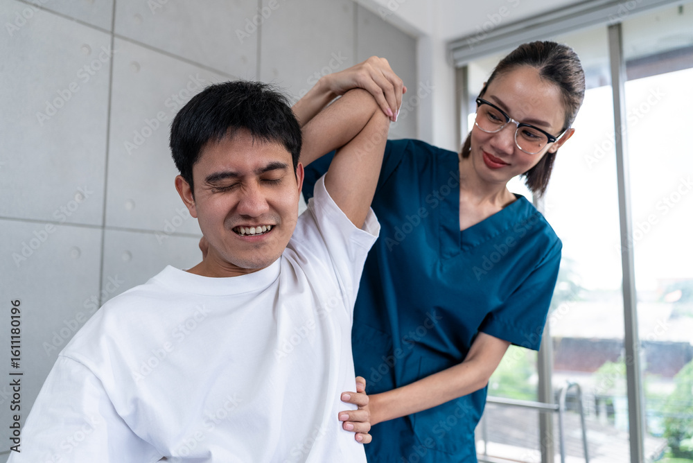 Obraz premium Young asian man patient undergoes chiropractic physical therapy under the supervision of a smiling woman physical therapist in a physical therapy clinic.