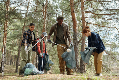 Slika na platnu Group of young adult and teenager multiethnic volunteers cleaning forest, collec
