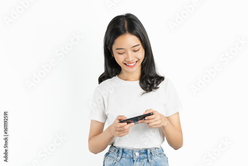 Happy young Asian woman playing an online game on a smartphone on white background.