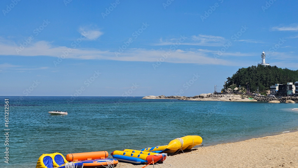 Fototapeta premium 강원도 속초 해수욕장 등대와 보트가 있는 해변 풍경