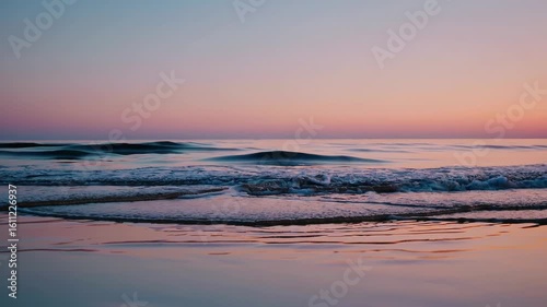 Experience the serene beauty of twilight by the ocean with gentle waves and calming hues of dusk