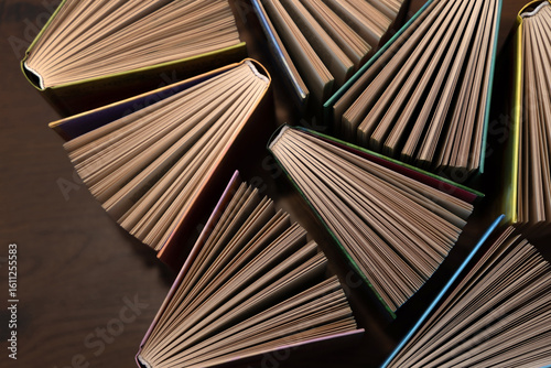 Hardcover books, colored covers textbooks, top view, on wooden floor. Books and reading are necessary for self-improvement, gaining knowledge and success in career, business and personal life.