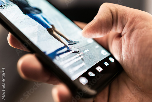 Short viral video on social media. Trend reel content in phone screen. App and platform for clips, live streaming or promotion campaign. Watching digital entertainment online. Man with smartphone.