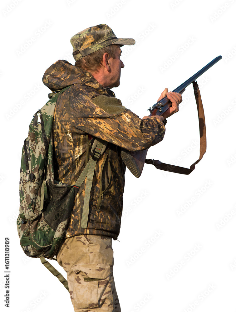 Obraz premium Hunting period, autumn season open. A hunter with a gun in his hands in hunting clothes in the autumn forest in search of a trophy. A man stands with weapons and hunting dogs tracking down the game.