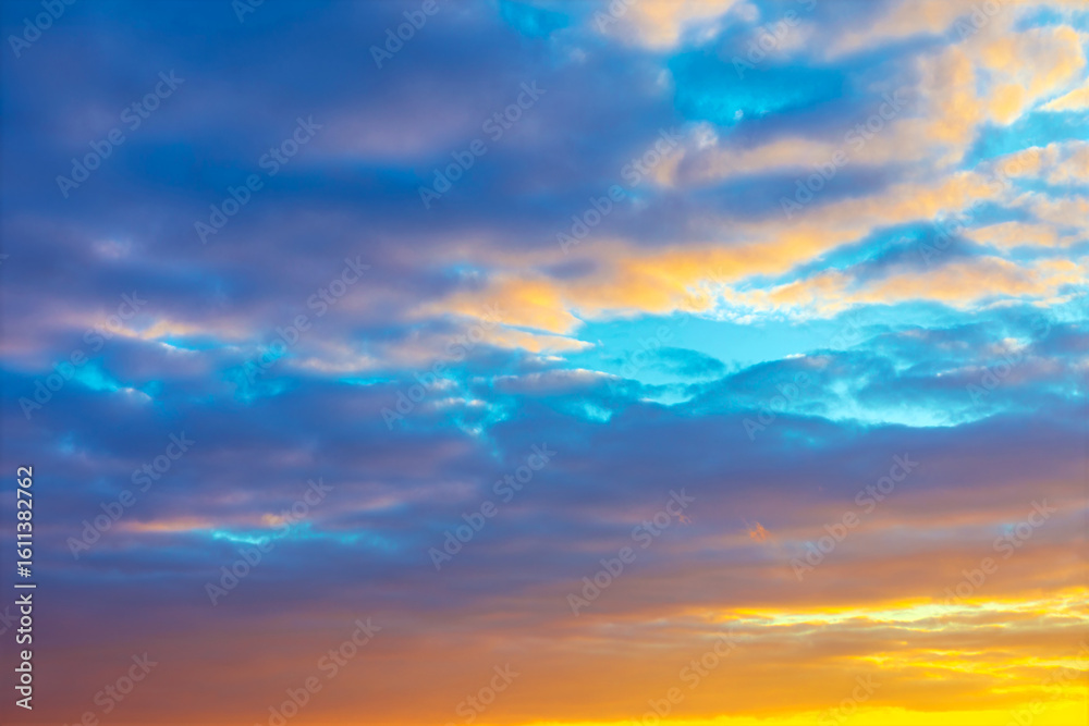 Obraz premium Layers of clouds, illuminated by the golden light of the setting sun. Sunset clouds a beautiful mix of vibrant colors