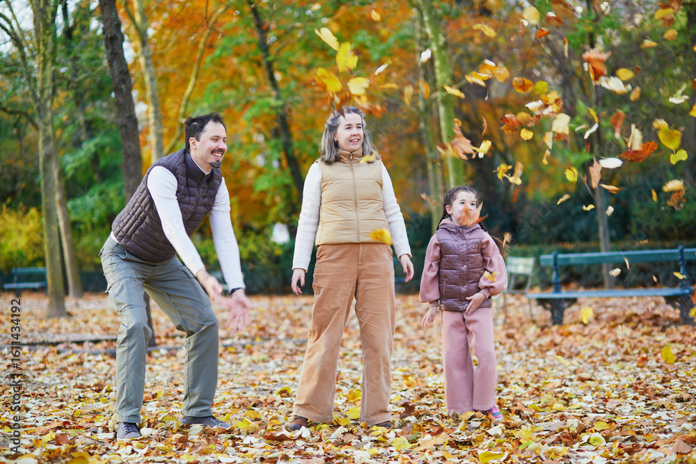 Naklejka premium Happy family of three, father, mother and daughter enjoying family time together in Luxembourg garden of Paris, France.