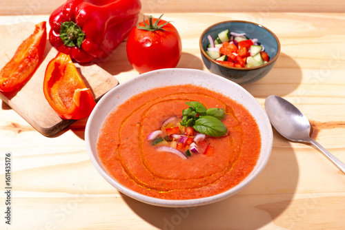 Fresh tomato and bell pepper gazpacho with basil and onion — overhead, natural light.