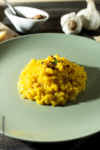 Saffron risotto in a rustic composition with garlic and parmesan cheeseù