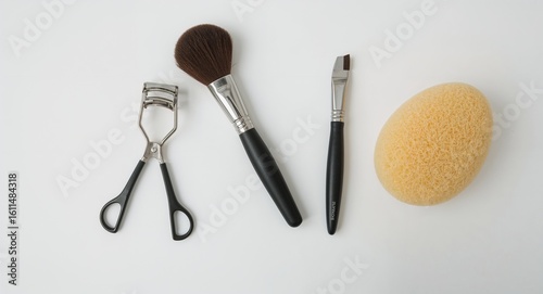 Set of beauty tools like tweezers eyelash curler brush sponge and razor on plain white background