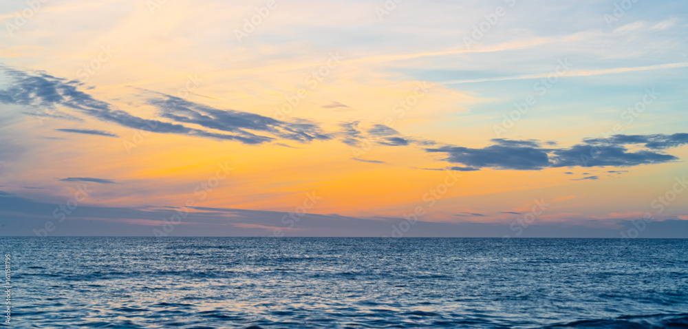 Fototapeta premium A Serene Sunset Over Coastal Waves, Beautifully Reflecting the Colors of the Sky