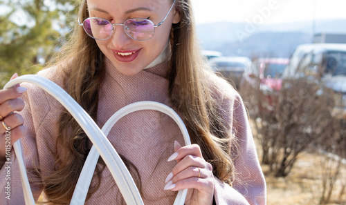 Girl with glasses looks into her purse