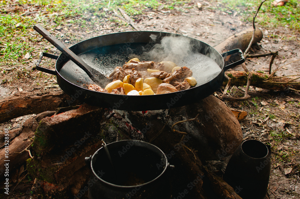 paellera grande sobre el fuego. holla grande tipo disco de hierro, cocinando al aire libre en la naturaleza. paellera grande sobre el fuego. holla grande tipo disco de hierro, cocinando al aire libre en la naturaleza.