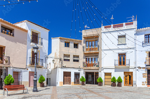 Fototapeta Naklejka Na Ścianę i Meble -  Old town Calpe city historical centre with typical white houses colorful traditional buildings on small square Villa Plaza in sunny summer day, province of Alicante, Valencian Community, Spain