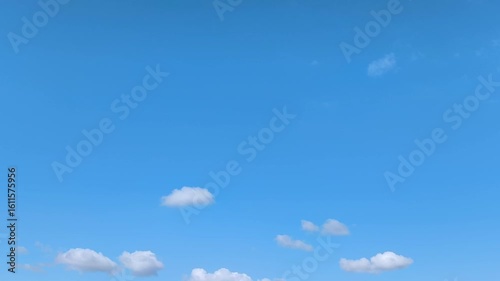 Filming of white clouds moving across the blue sky