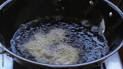 Close up slow motion of frying crispy fried nugget food fried in boiling oil in a frying pan